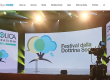 Stage with large screens and banners for Cattolica Assicurazioni at a festival, camera filming the event.