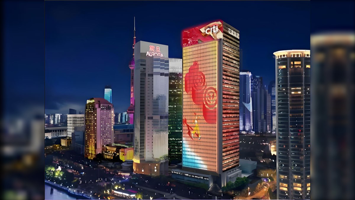 Citigroup Tower Facade Biggest LED Screen Project LED Display Manufacturer in China EagerLED Nighttime city skyline with illuminated skyscrapers and a tall glass building displaying red abstract artwork on its facade