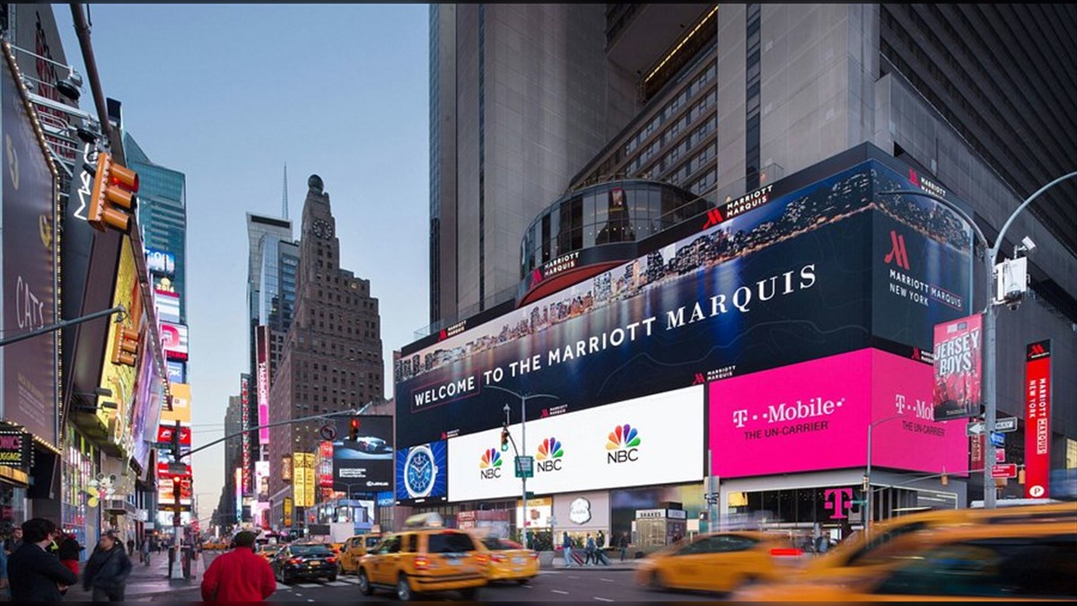 New York Marriott Marquis Biggest LED Screen Project LED Display Manufacturer in China EagerLED Bustling Times Square at dusk with a large Marriott Marquis sign and bright digital billboards yellow taxis and pedestrians