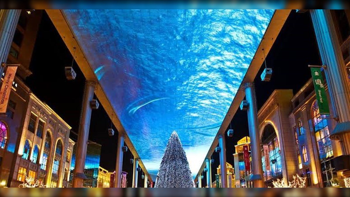 Qin Han Tang Emporium Biggest LED Screen Project LED Display Manufacturer in China EagerLED Indoor shopping corridor at night with a tall illuminated Christmas tree centered between two colonnades and a blue illuminated ceiling overhead