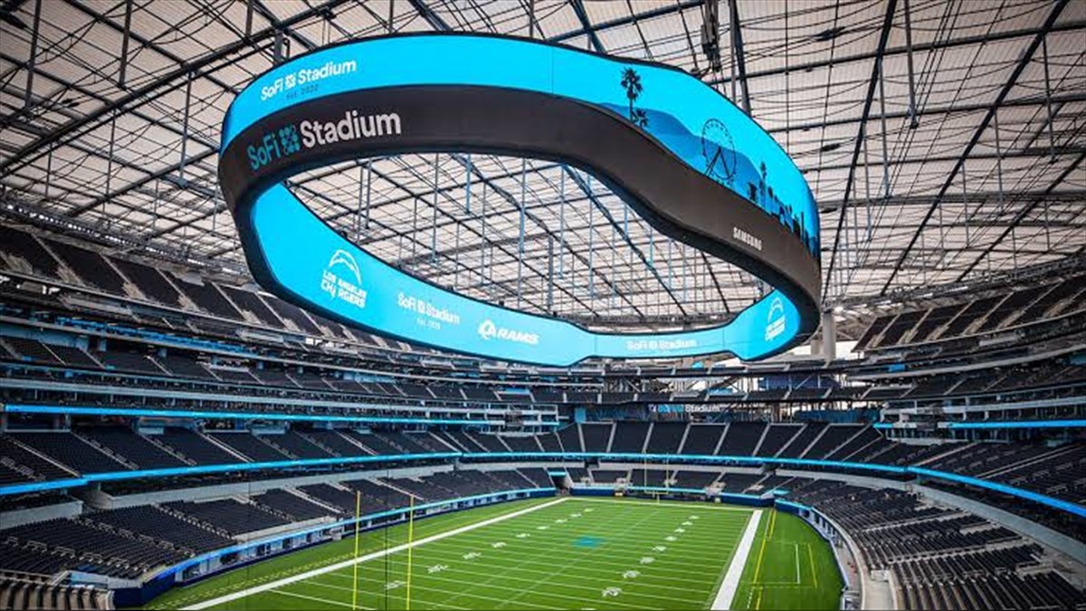 SoFi Stadium Infinity Screen Biggest LED Screen Project LED Display Manufacturer in China EagerLED Interior view of SoFi Stadium with a circular blue video board hanging above the empty stands and green football field under stadium lights