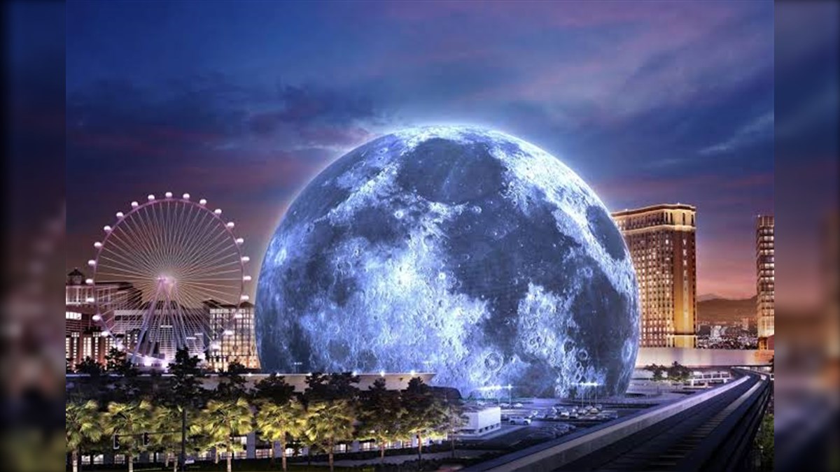 Sphere Exosphere Biggest LED Screen Project LED Display Manufacturer in China EagerLED A giant glowing blue moon dominates a cityscape at dusk with a lit Ferris wheel and tall buildings nearby
