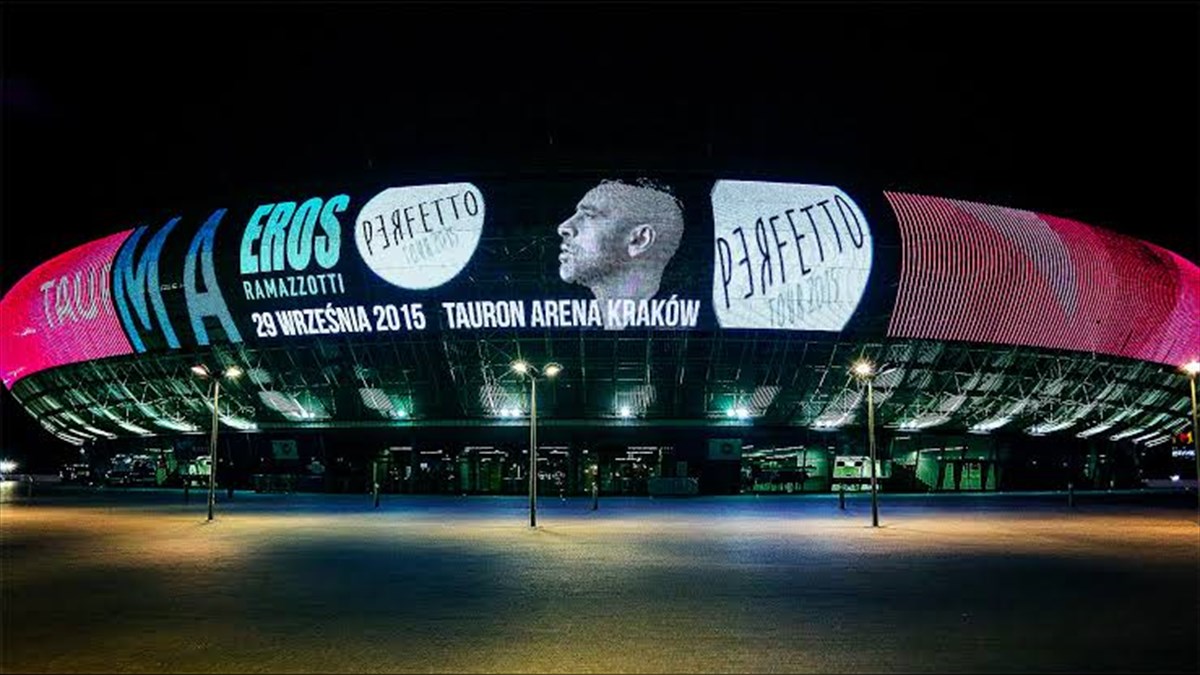 Tauron Arena Media Facade Biggest LED Screen Project LED Display Manufacturer in China EagerLED Night view of a large arena with a bright curved LED banner advertising a concert Kraków Tauron Arena 2015 poster