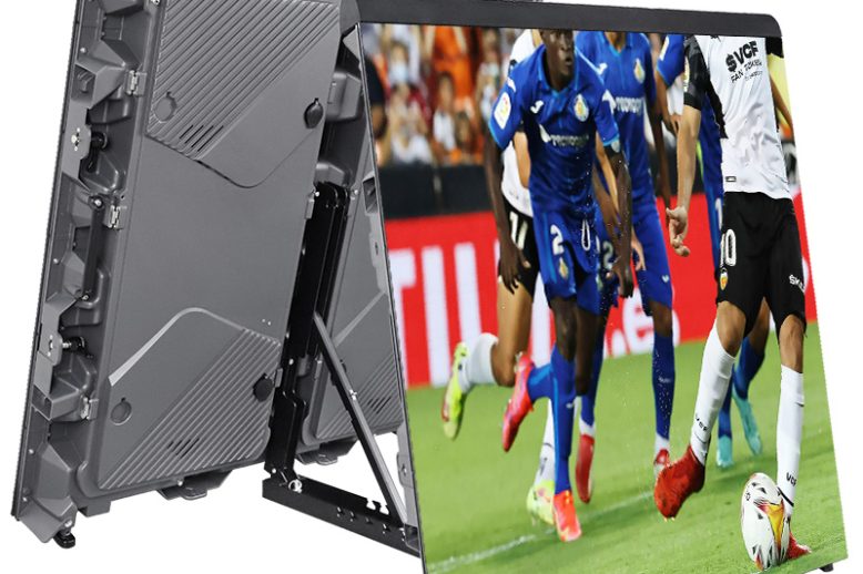 EA960SP5-Stadium-LED-Display-9 Grand panneau publicitaire/d'affichage LED installé sur un support, incliné pour diffuser un match de football sur son écran, avec les joueurs visibles sur le panneau avant.