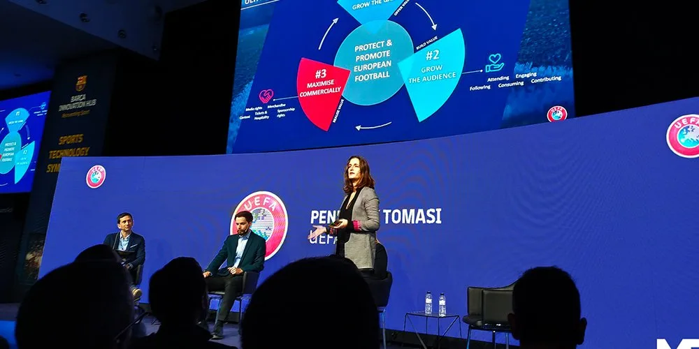 Curved LED screen behind the speakers at a corporate conference