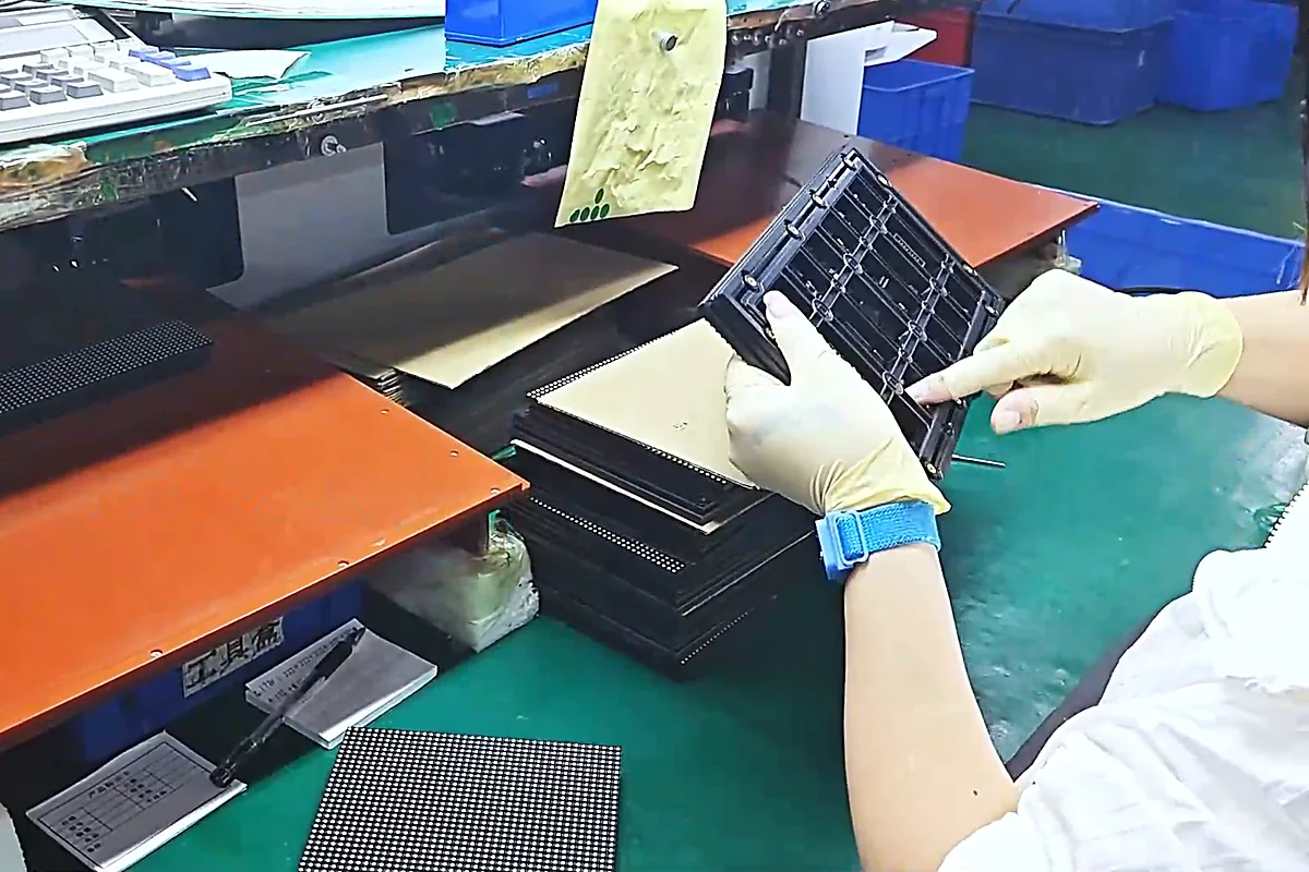 QC inspector checking the back of a finished LED module before labeling