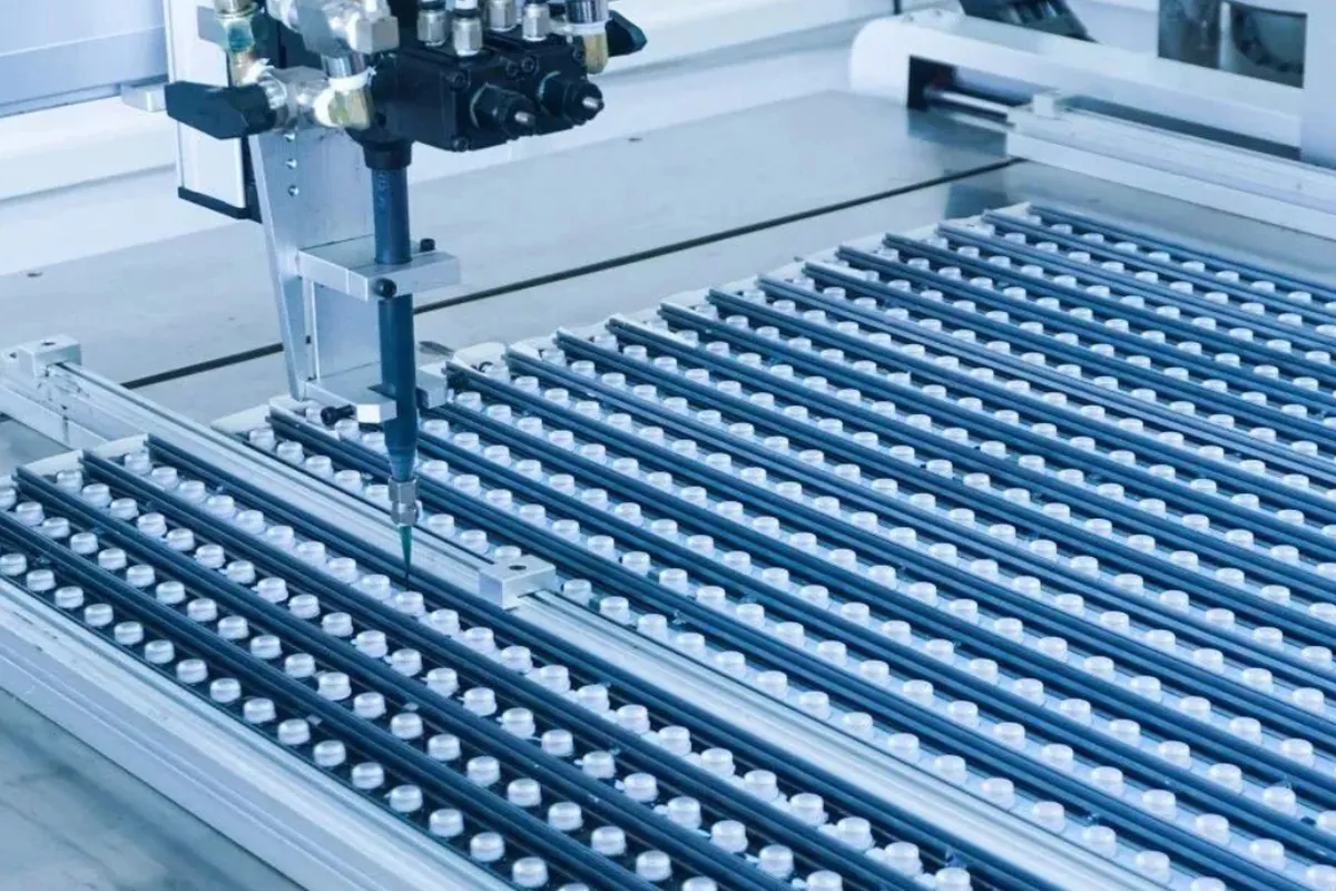 Automated dispensing head applying glue to rows of LED modules