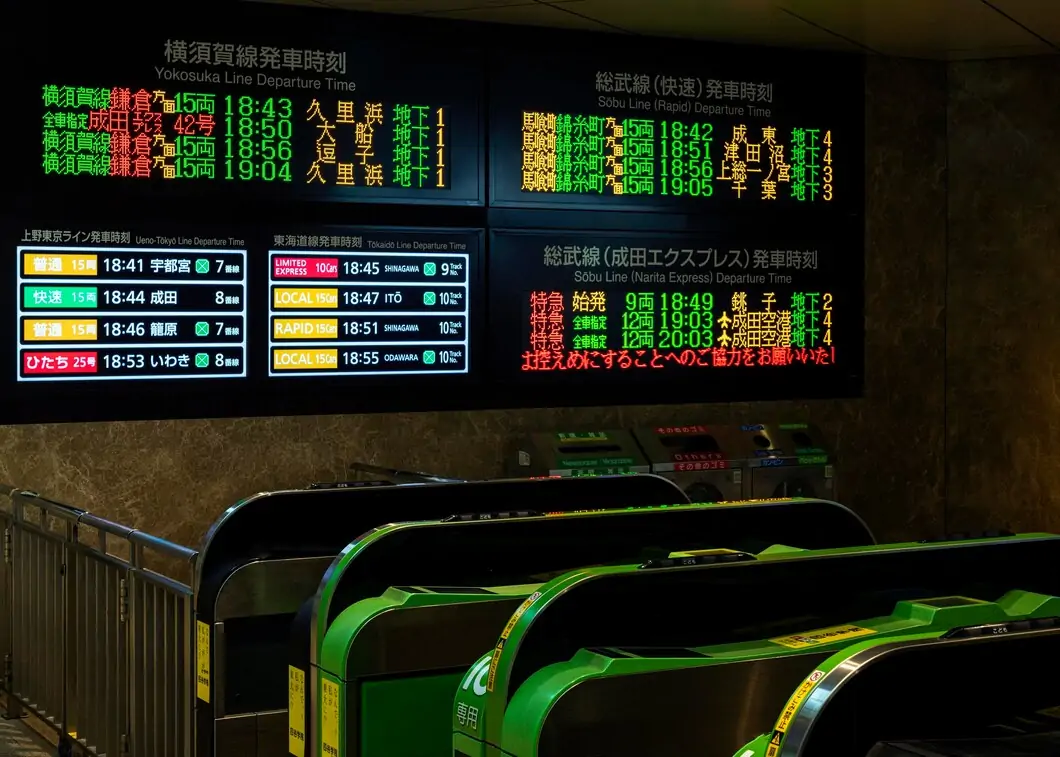 Paneles LED de salidas sobre las puertas de acceso en una estación de tren japonesa.