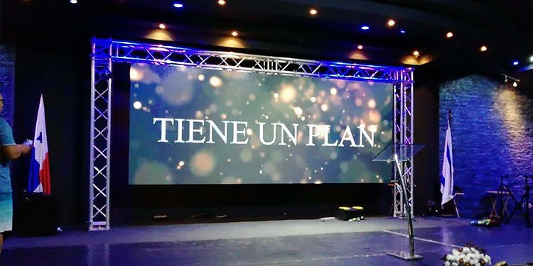 Stage LED video wall hanging from a truss above a conference stage